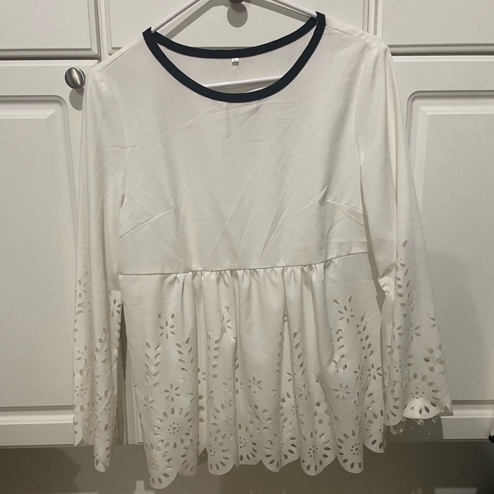 Women’s medium blouse with floral cut outs. Long sleeve with black trim